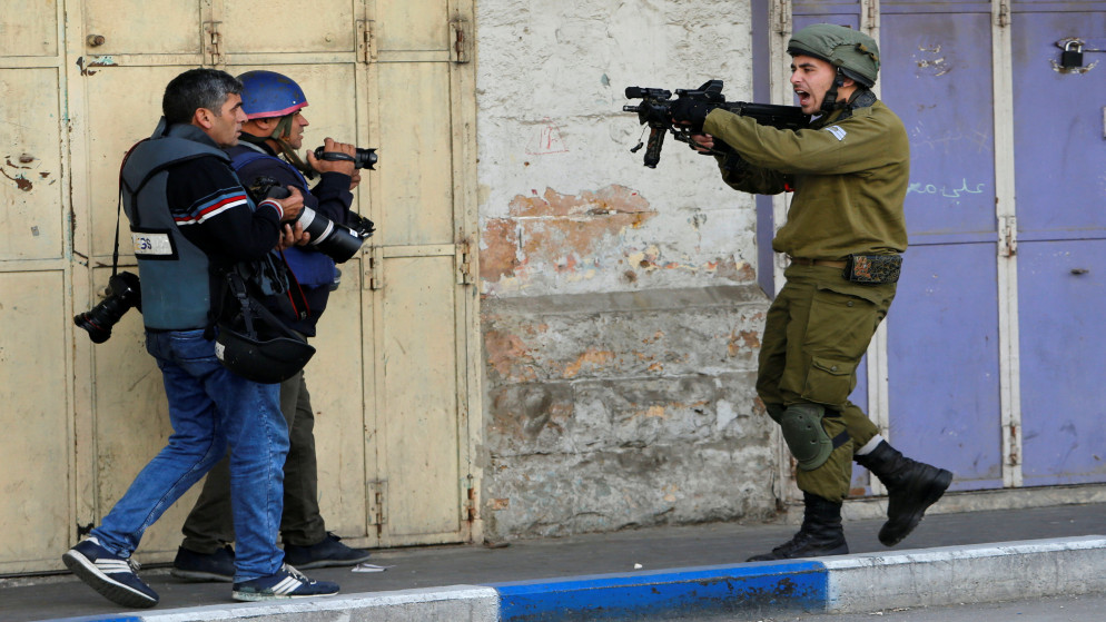 صورة أرشيفية لجندي من الاحتلال الاسرائيلي يعتدي على فلسطينيين. (وفا)