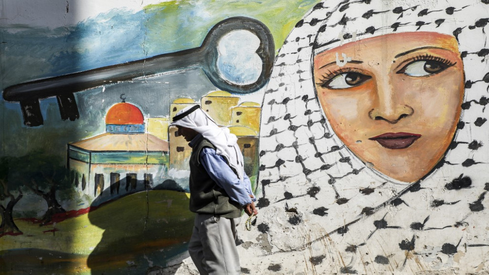 لوحة جدارية تصور امرأة فلسطينية ترتدي وشاح "كوفية" بجانب مفتاح فوق قبة الصخرة المشرفة في مخيم جنين للاجئين الفلسطينيين شمال الضفة الغربية المحتلة ، 10 سبتمبر ، 2020 . (أ ف ب)