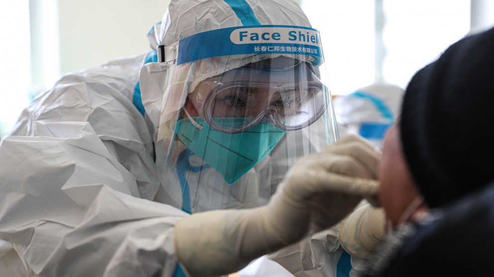 عامل طبي يأخذ عينة مسحة من شخص لاختبار فيروس كورونا. شنيانغ بمقاطعة لياونينغ شمال شرق الصين. 31 ديسمبر 2020. (أ ف ب)