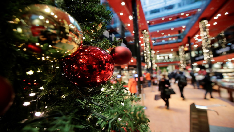 يُنظر إلى زينة عيد الميلاد بينما يمشي الناس في مركز تسوق مفتوح أثناء إغلاق البلاد ، وسط جائحة فيروس كورونا (COVID-19)، برلين، ألمانيا، 23 كانون الأول/ ديسمبر 2020. (رويترز)