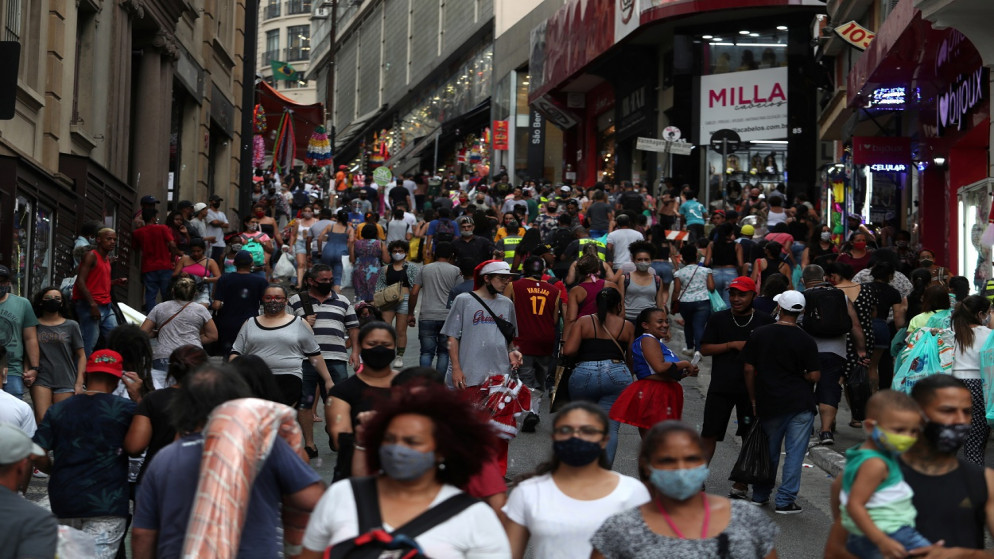 أشخاص يسيرون في شارع لتسوق قبل عيد الميلاد، وسط تفشي مرض فيروس كوفيد-19 وسط مدينة ساو باولو، البرازيل، 21 كانون الأول/ ديسمبر 2020. (رويترز)