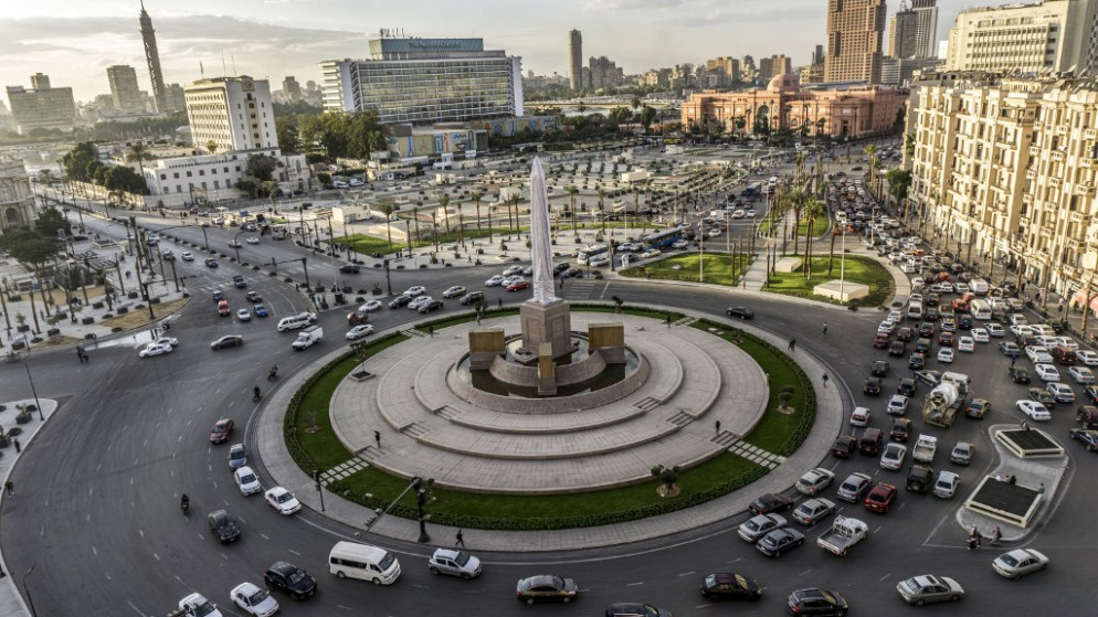 مركبات تسير عبر الدوار الرئيسي المزين بمسلة رمسيس الثاني في ميدان التحرير في وسط العاصمة المصرية القاهرة. (أ ف ب)