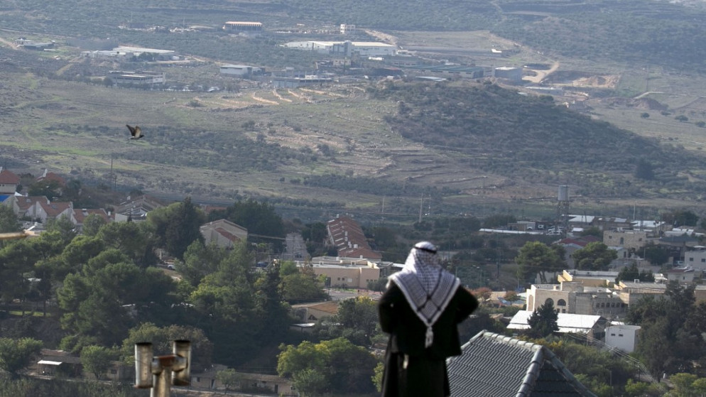 فلسطيني ينظر باتجاه مستوطنة شافي شومرون المقامة بجوار قرية الناقورة الفلسطينية، غربي نابلس في الضفة الغربية المحتلة، 23 نوفمبر/تشرين الثاني 2020. (أ ف ب)