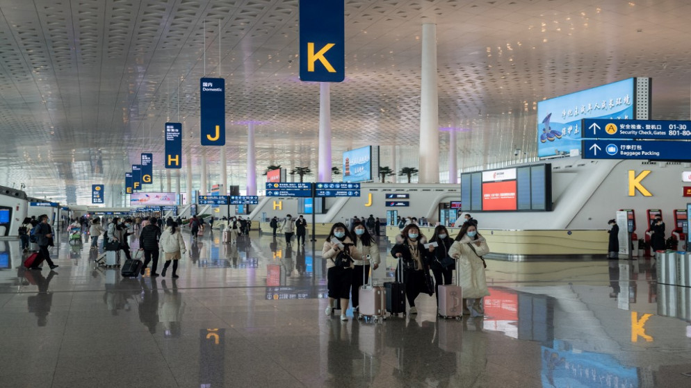 مسافرون في صالة المغادرة رقم 3 بالمطار الدولي في ووهان.14 كانون الثاني/ يناير 2021.( نيكولاس عصفوري / أ ف ب)