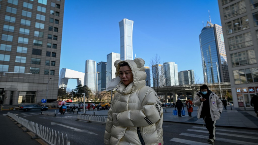 مشاه يعبرون أحد شوارع الحي التجاري المركزي (سي بي دي) في بكين .18 يناير 2021. (وانغ تشاو / أ ف ب)