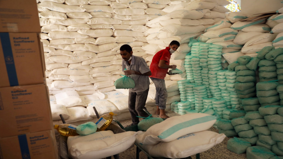 عمال يعدون مواد غذائية للمستفيدين في مركز توزيع أغذية يدعمه برنامج الغذاء العالمي في صنعاء اليمنية. 03/06/2020. (رويترز)