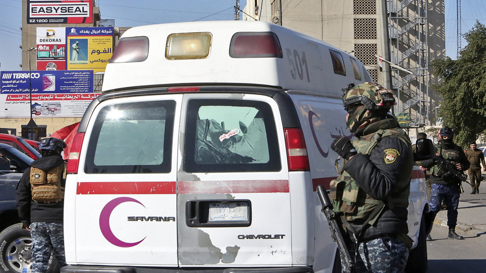 قوات أمن عراقية حول سيارة إسعاف بالقرب من موقع هجوم انتحاري مزدوج في بغداد. 21 كانون الثاني/يناير 2021. (أ ف ب)