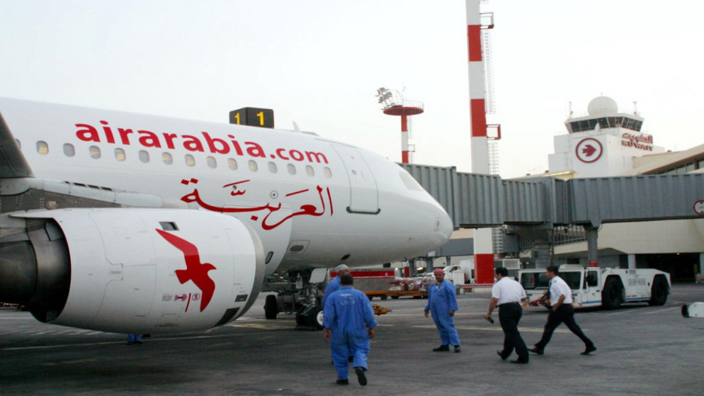 صورة تظهر طاقما يقف بجانب طائرة إيرباص 320 تابعة لشركة طيران الشارقة ، العربية للطيران ، على مدرج مطار الكويت الدولي.29 أكتوبر 2003. (أ ف ب)
