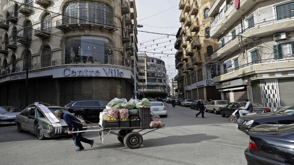 شخص يسحب عربته اليدوية في مدينة طرابلس الساحلية اللبنانية، 26 كانون الثاني/يناير 2021. (جوزيف عيد/ أ ف ب)