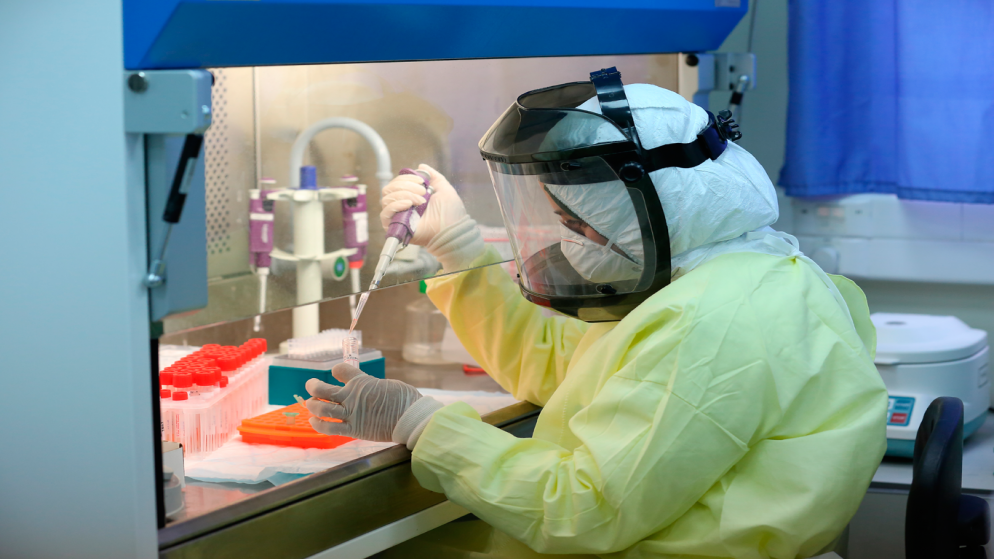 عاملة في مختبر فحص عينات فيروس كورونا المستجد. (وفا)