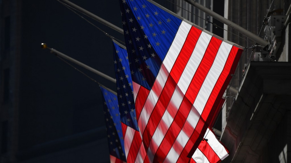 علم الولايات المتحدة الأميركية فوق مبنى بورصة نيويورك (NYSE) في وول ستريت .12 يناير 2021. (أ ف ب)