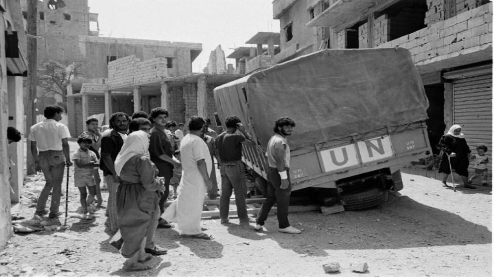 لاجئون فلسطينيون يقفون حول سيارة تابعة لأونروا في مخيم البقعة للاجئين الفلسطينيين قرب العاصمة عمّان في عام 1970. أ ف ب/أرشيف أونروا