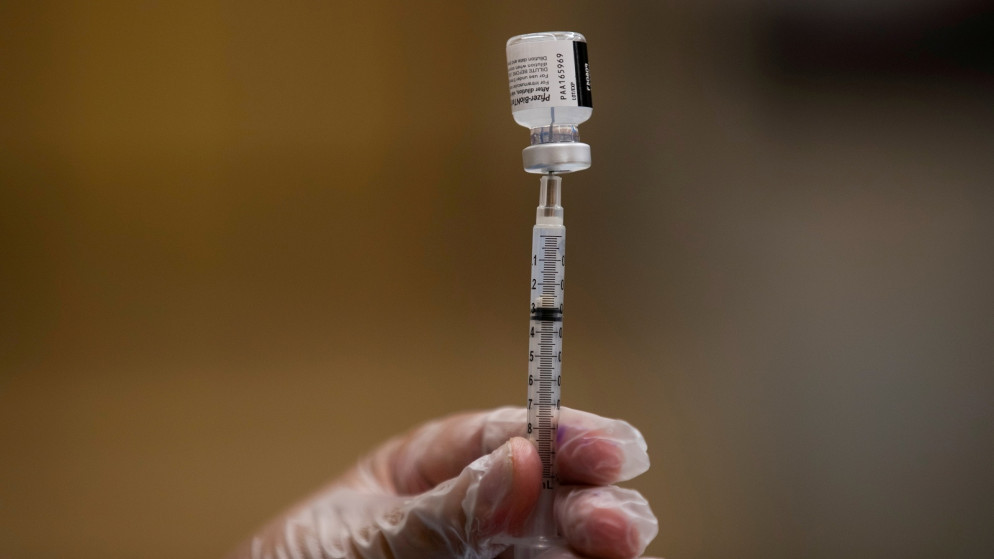 عامل رعاية صحية يحضر جرعة من لقاح واق من فيروس كورونا (رويترز)