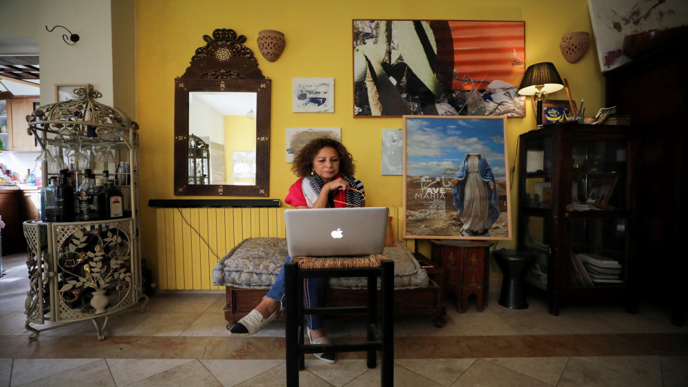الممثلة الفلسطينية هدى الإمام تشاهد فيلمها السلام عليك يا مريم على منصة نتفليكس في منزلها في القدس المحتلة. (رويترز)