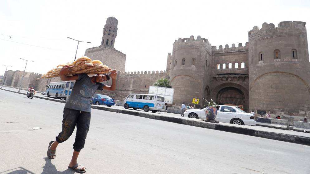فتى مصري يحمل الخبز في شارع في القاهرة. (رويترز)