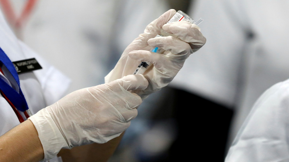 عامل رعاية صحية يحضر حقنة من لقاح واق من فيروس كورونا (رويترز)
