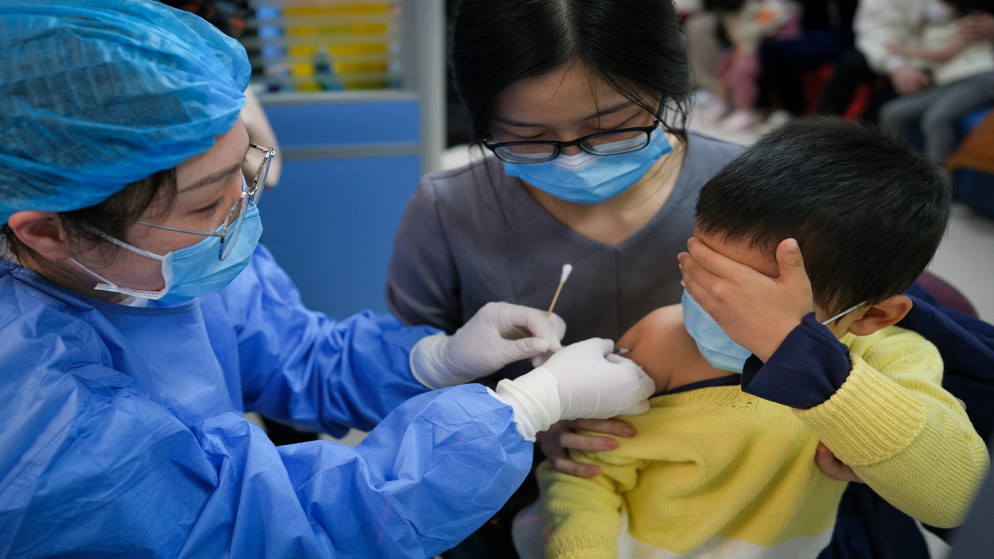 عاملة طبيه تعطي جرعة من لقاح كورونا، لطفل في روضة الأطفال في المستشفى، في تشونغتشينغ، الصين، 10 تشرين الثاني/ نوفمبر 2021. (رويترز)
