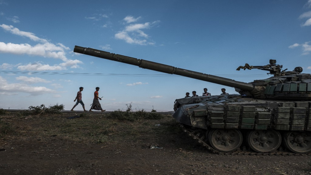 يسير شبان بجوار دبابة مهجورة تابعة لقوات تيغرايان جنوب بلدة مهوني بإثيوبيا، 11 كانون الأول/ ديسمبر 2020. (أ ف ب)