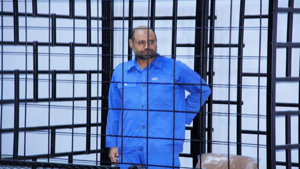 سيف الإسلام القذافي، خلال جلسة استماع خلف القضبان بقاعة محكمة في الزنتان. (رويترز)