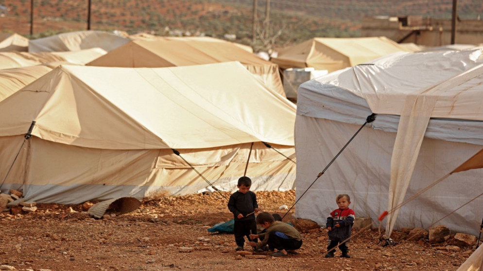 أطفال يلعبون في مخيم للنازحين السوريين بالقرب من محافظة إدلب. 01/12/2021. (عمر الحاج قدور/ أ ف ب)