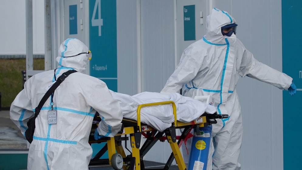 متخصصون طبيون ينقلون شخصا على نقالة خارج مستشفى للمرضى المصابين بفيروس كورونا، ضواحي موسكو، روسيا، 2 يوليو/تموز 2021. (رويترز)