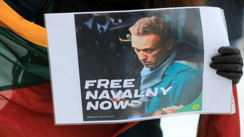 شخص يحمل لوحة تحمل صورة المعارض الروسي أليكسي نافالني. (أ ف ب)