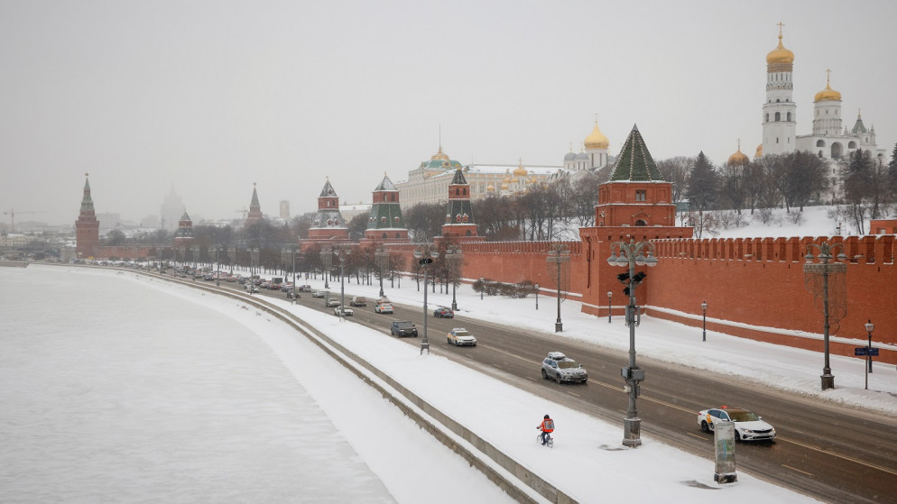 سيارات تسير على طول جسر لنهر موسكفا بالقرب من الكرملين أثناء تساقط الثلوج في موسكو، روسيا، 14/1/2021. (رويترز )