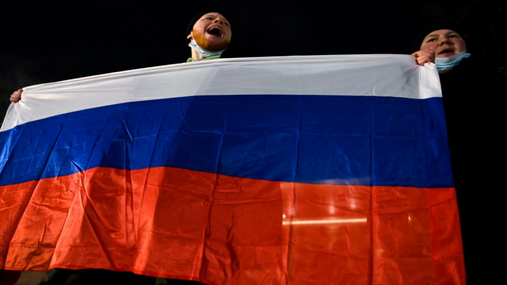 محتجان في وسط موسكو يرفعان العلم الروسي ضد قرار محكمة أمرت بسجن زعيم المعارضة أليكسي نافالني لما يقرب من ثلاث سنوات، 2 شباط/فبراير 2021. (أ ف ب)