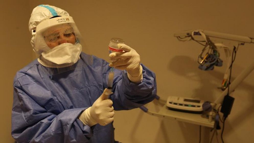 عاملة في مختبر فحص عينات فيروس كورونا المستجد. (وفا)