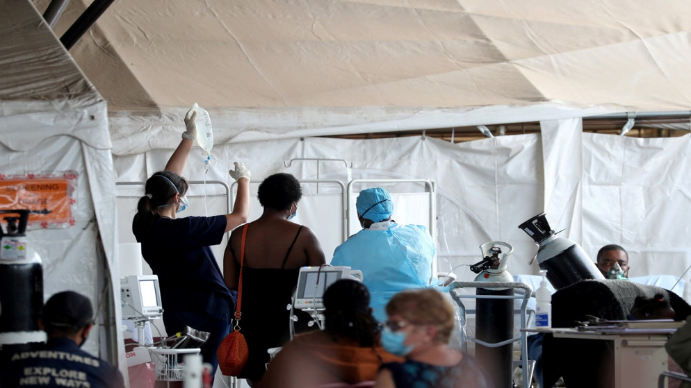 عاملون في مجال الصحة يحضرون المرضى في خيام في موقف سيارات مستشفى، وسط إغلاق وطني بسبب مرض فيروس كورونا، في بريتوريا، جنوب إفريقيا، 11/1/2021. (رويترز / سيفيوي سيبيكو )