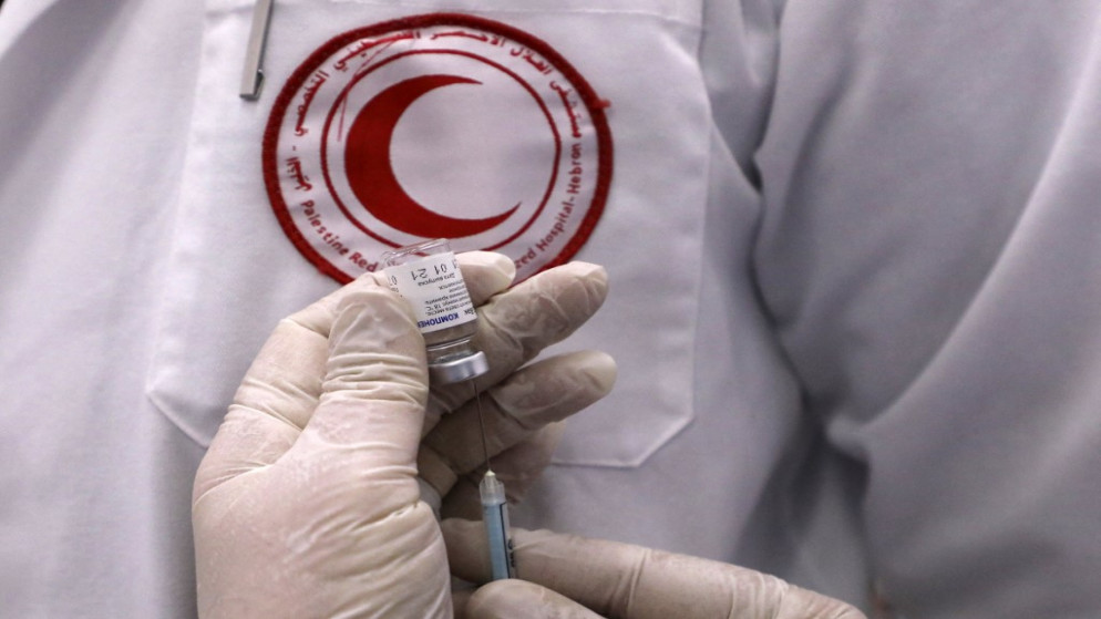 عامل صحي في الهلال الأحمر الفلسطيني يحضر جرعة من اللقاح الروسي "Sputnik V Covid-19" في مدينة الخليل بالضفة الغربية المحتلة. 11 فبراير 2021. ( أ ف ب)
