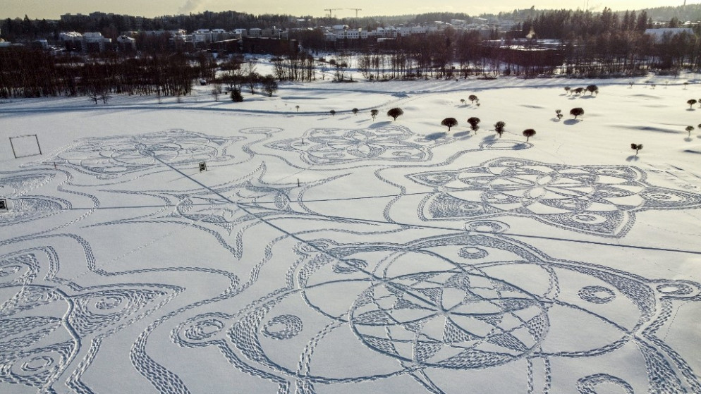 صورة جوية تظهر رسمًا ثلجيًا مصنوعًا بالكامل من آثار الأقدام على ملعب للجولف خارج العاصمة الفنلندية هلسنكي . 10 فبراير 2021. (أ ف ب)