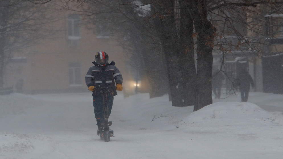 شخص يركب دراجة بخارية أثناء تساقط الثلوج بغزارة في موسكو ، روسيا .12 فبراير 2021. (رويترز / مكسيم شيميتو)