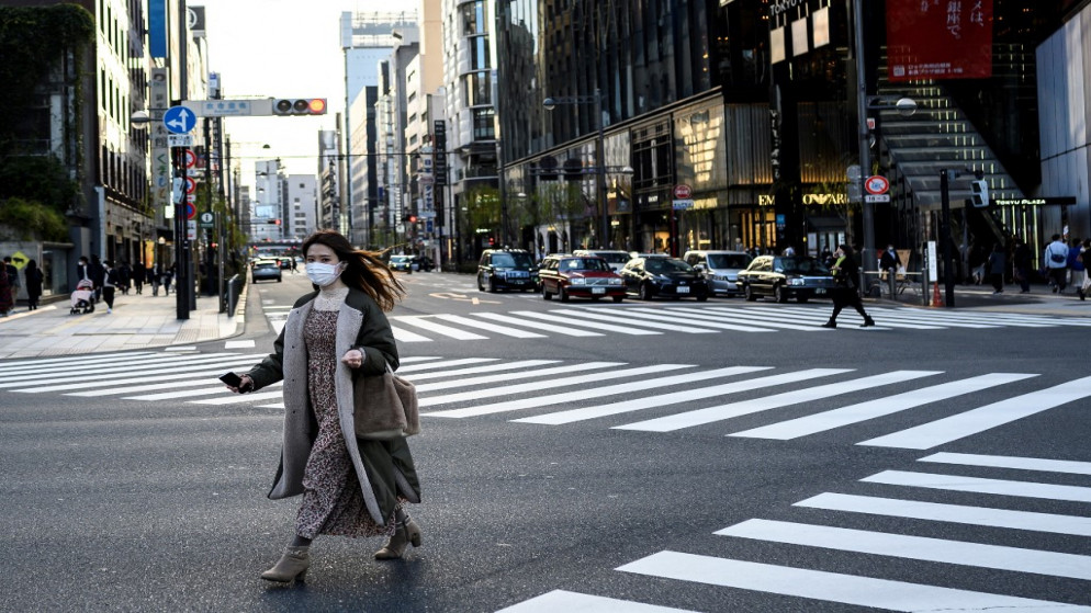 سيدة خلال عبورها شارعًا في طوكيو .14 فبراير 2021.(أ ف ب)