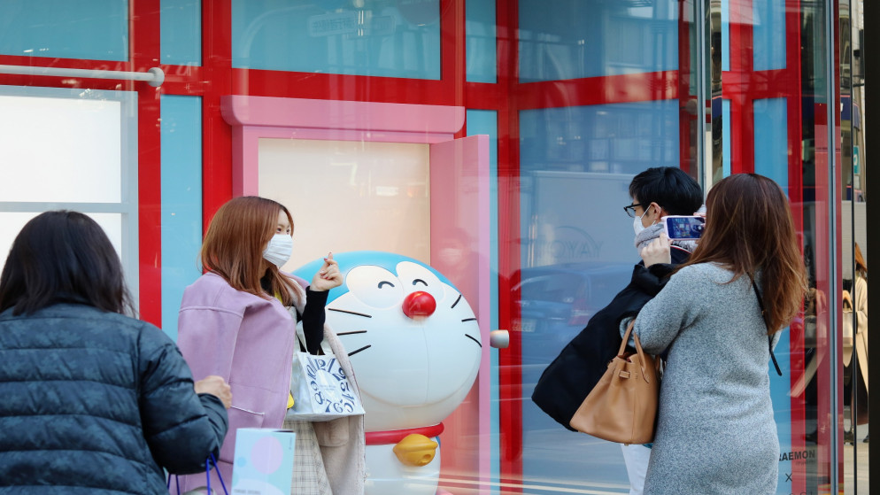 أشخاص يرتدون كمامات للوقاية من كوفيد-19 يلتقطون صورا من نافذة متجر غوتشي في منطقة جينزا بطوكيو. 03/02/2021. (shutterstock)