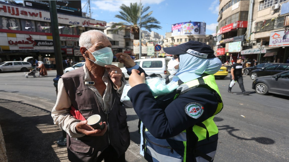 أفراد من الشرطة الفلسطينية خلال يوم إرشادي توعوي حول إجراءات الوقاية من فيروس كورونا وسط مدينة نابلس. 2020/10/4. (أيمن نوباني/ وفا)