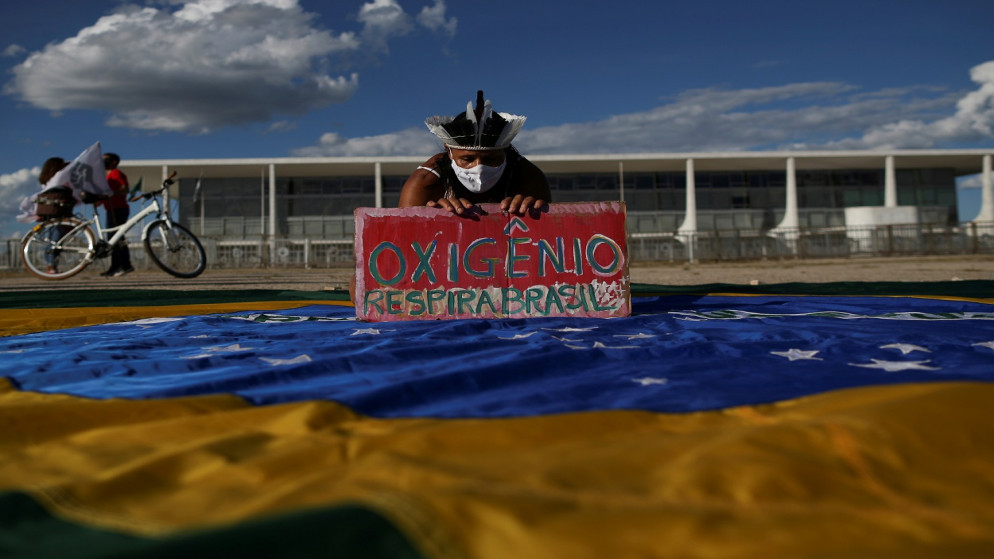 متظاهر يحمل لافتة كتب عليها "الأكسجين يتنفس البرازيل" خلال احتجاج على الرئيس البرازيلي جاير بولسونارو وتعامله مع تفشي الفيروس، البرازيل ، 24 كانون الثاني/يناير  2021. (رويترز)