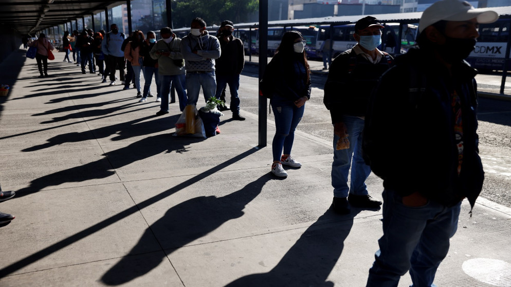 أشخاص يرتدون كمامات للوقاية من فيروس كورونا المستجد خلال انتظارهم حافلة نقل عام في المكسيك، 26 كانون الثاني/ يناير 2021. (رويترز)