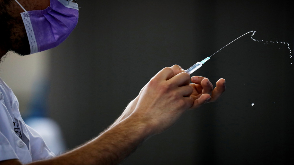 عامل في القطاع الصحي يحضر جرعة من اللقاح المضاد لكوفيد-19. (رويترز)