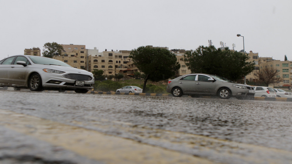 مركبات تسير في شارع رئيسي في عمّان في يوم ماطر. (صلاح ملكاوي/ المملكة)