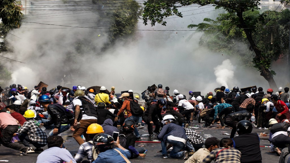 متظاهرون يبتعدون عن الغاز المسيل للدموع الذي أطلقته الشرطة خلال تظاهرة ضد الانقلاب العسكري في ماندالاي، 3 آذار/مارس 2021. (أ ف ب)