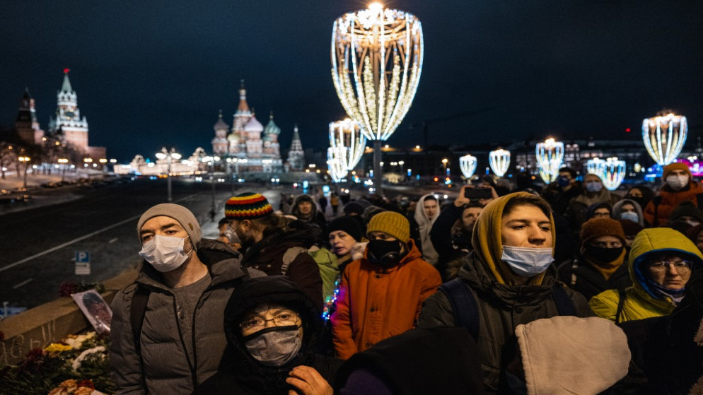 مواطنون روس يقفون دقيقة صمت وهم يحيون السياسي المعارض الراحل بوريس نيمتسوف ، على جسر في موسكو ، 27 فبراير 2021. (أ ف ب)