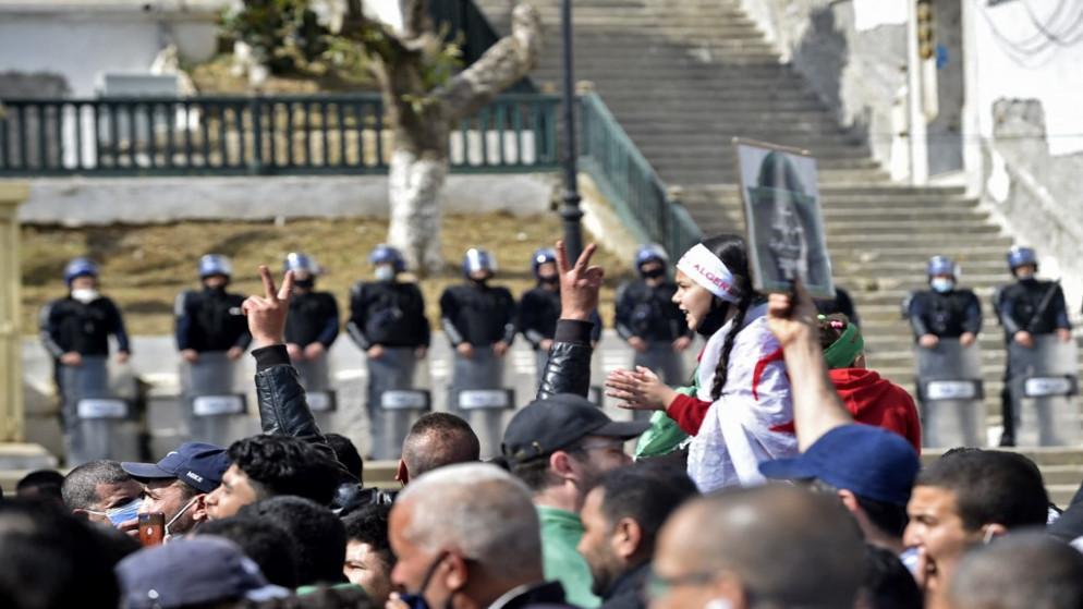 قوات الأمن الجزائرية تقوم بالحراسة أثناء مسيرة لمتظاهرين خلال احتجاجات مناهضة للحكومة في العاصمة الجزائر في 5 آذارمارس 2021. (أ ف ب)