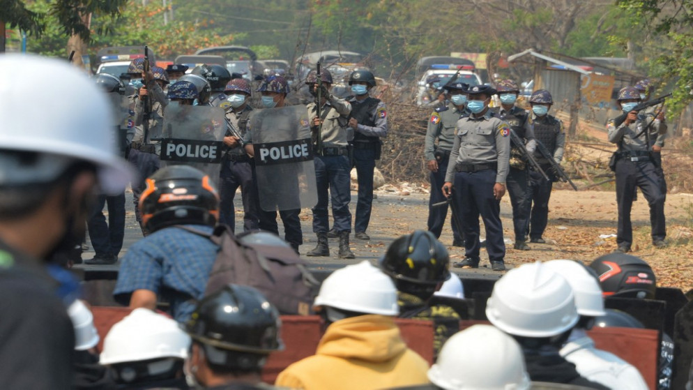 شرطة مكافحة الشغب تحمل أسلحتها النارية أثناء مواجهتها للمتظاهرين خلال تظاهرة ضد الانقلاب العسكري في نايبيداو في 8 مارس/آذار 2021. (أ ف ب)