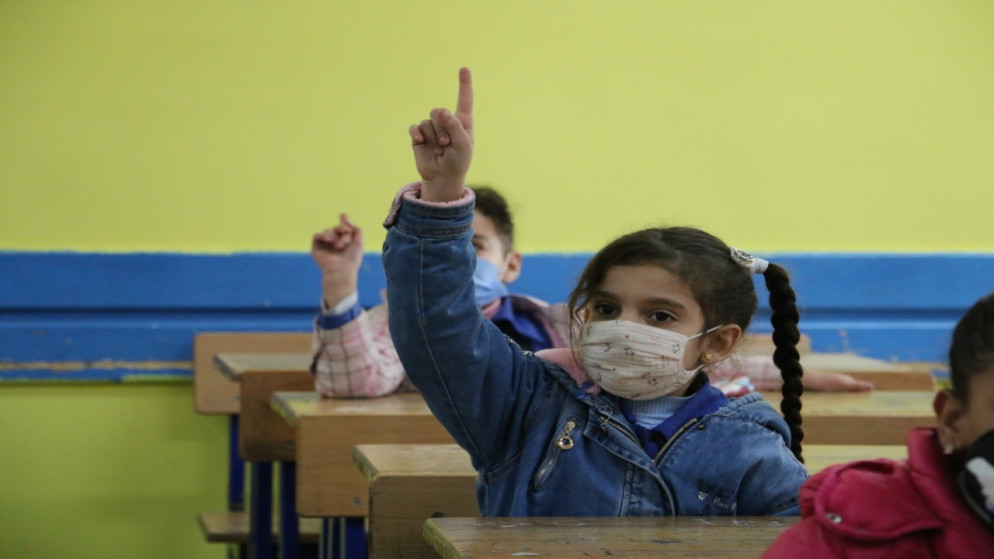 طالبة ترتدي كمامة للوقاية من كوفيد-19 في مدرسة تابعة لوكالة الأمم المتحدة لإغاثة وتشغيل اللاجئين الفلسطينين "أونروا" في الأردن. (أونروا)