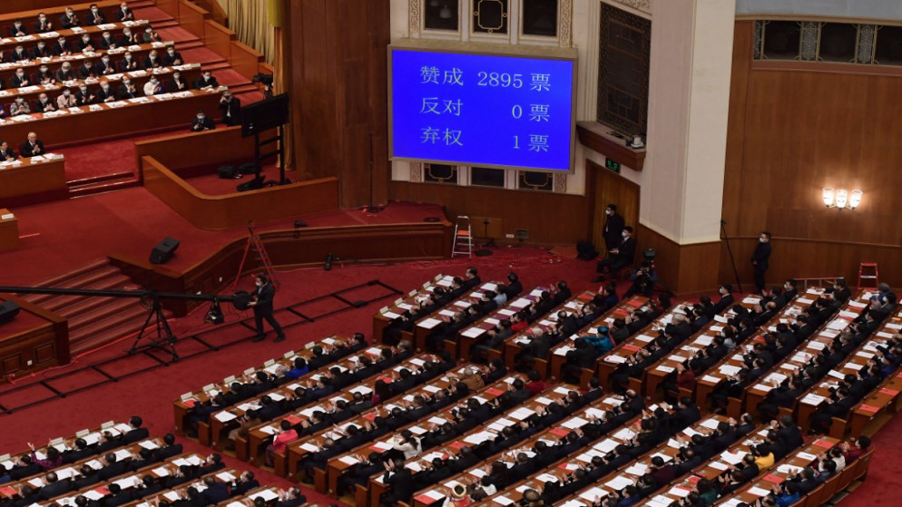 شاشة تظهر نتيجة التصويت على التغييرات في نظام الانتخابات في هونغ كونغ خلال الجلسة الختامية للمجلس الوطني لنواب الشعب في قاعة الشعب الكبرى في بكين .11 مارس 2021.(أ ف ب)