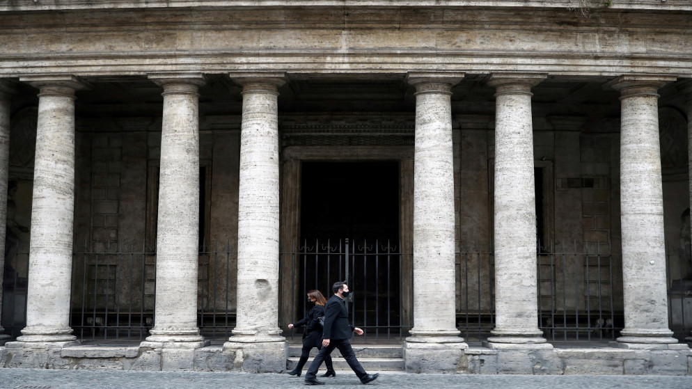 شخصان يسيران في شارع في العاصمة الإيطالية روما، 12 آذار/مارس 2021. (رويترز)