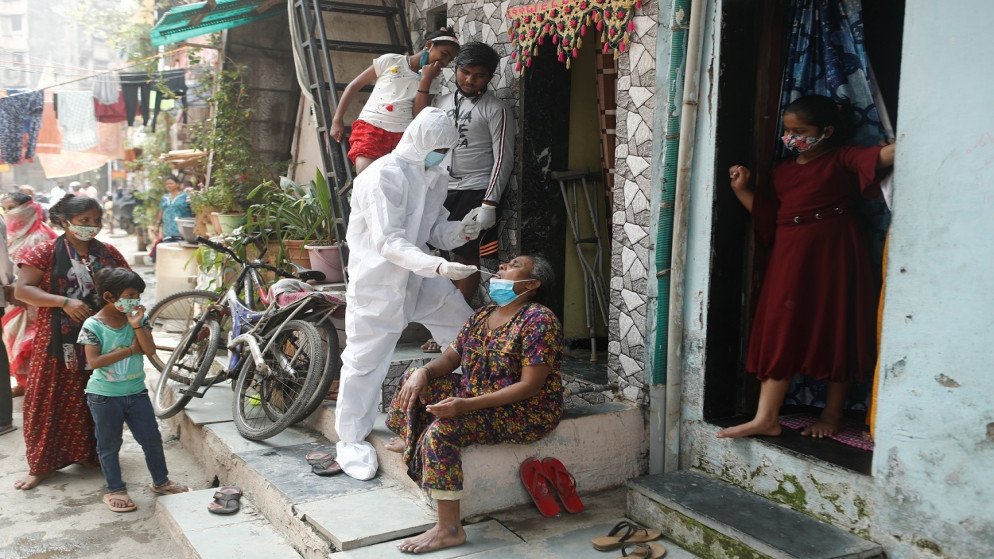 عامل رعاية صحية يرتدي معدات الوقاية الشخصية، يجمع عينة من السكان للكشف عن الفيروس، في مومباي، الهند، 23 شباط/ فبراير 2021. (رويترز)