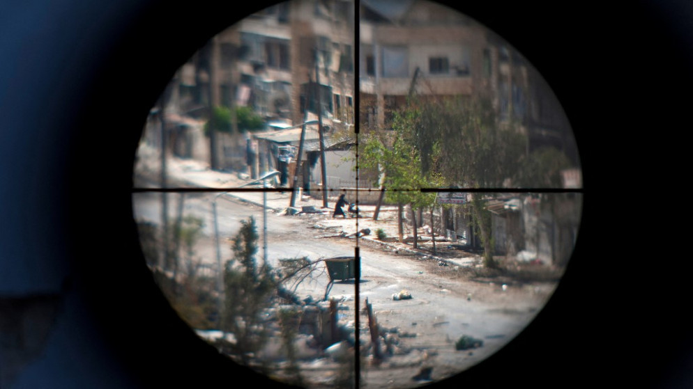 امرأة وطفلها يظهران من خلال منظار بندقية قناص مسلح، في مدينة حلب شمالي سوريا.29 أغسطس / آب 2012.(أ ف ب)