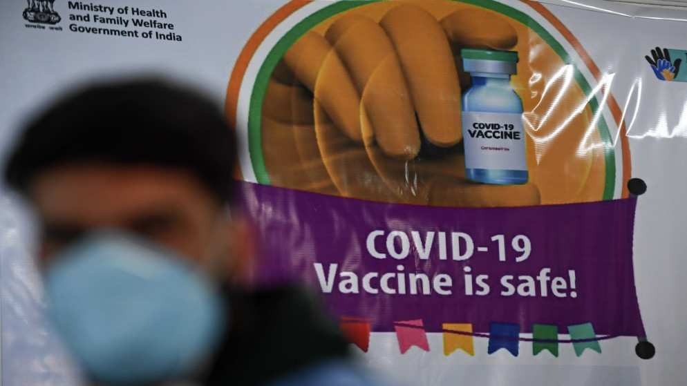 عامل طبي يمر بجانب لافتة أثناء التطعيم المستمر ضد فيروس كورونا. 22 يناير 2021. (أ ف ب)